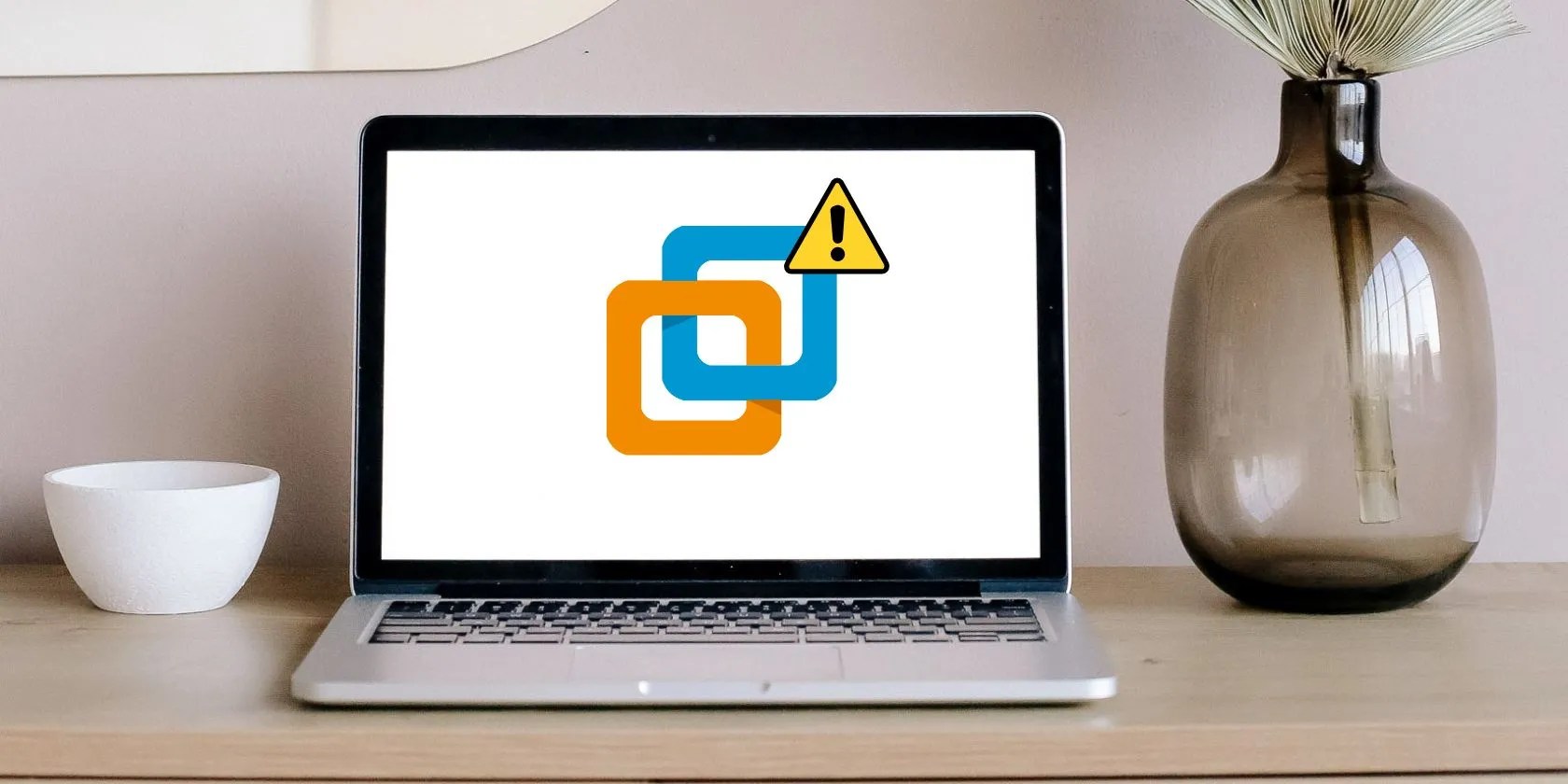 laptop placed on desk near flask and bowl