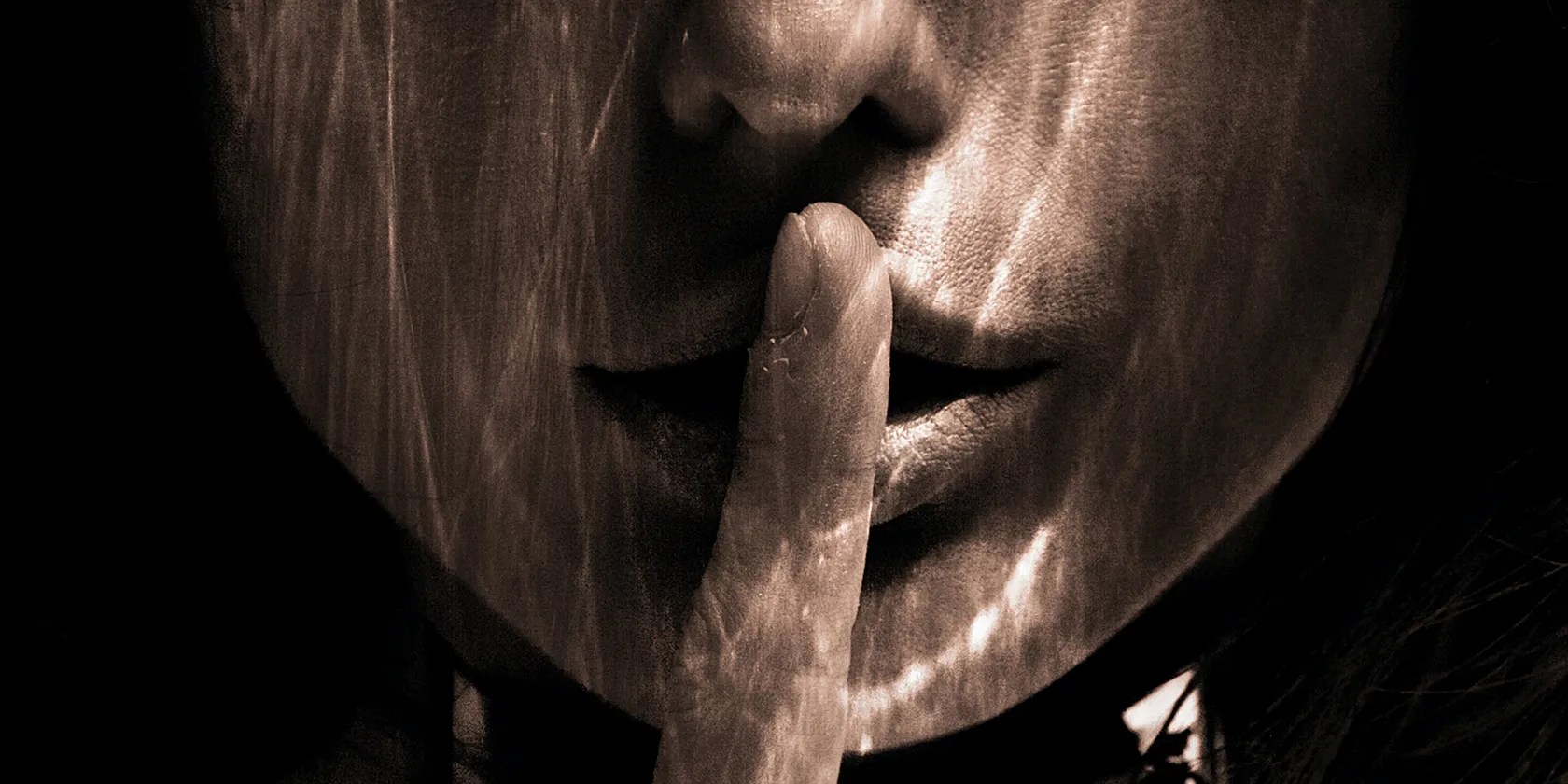 Image of a woman shushing the camera