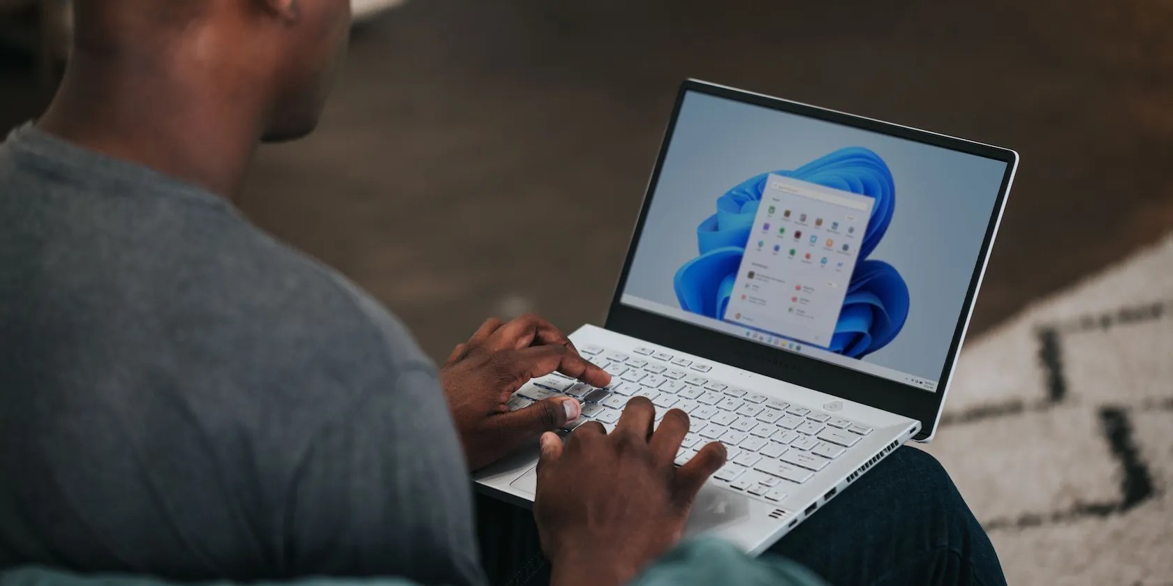 man using a windows laptop by placing it on his lap