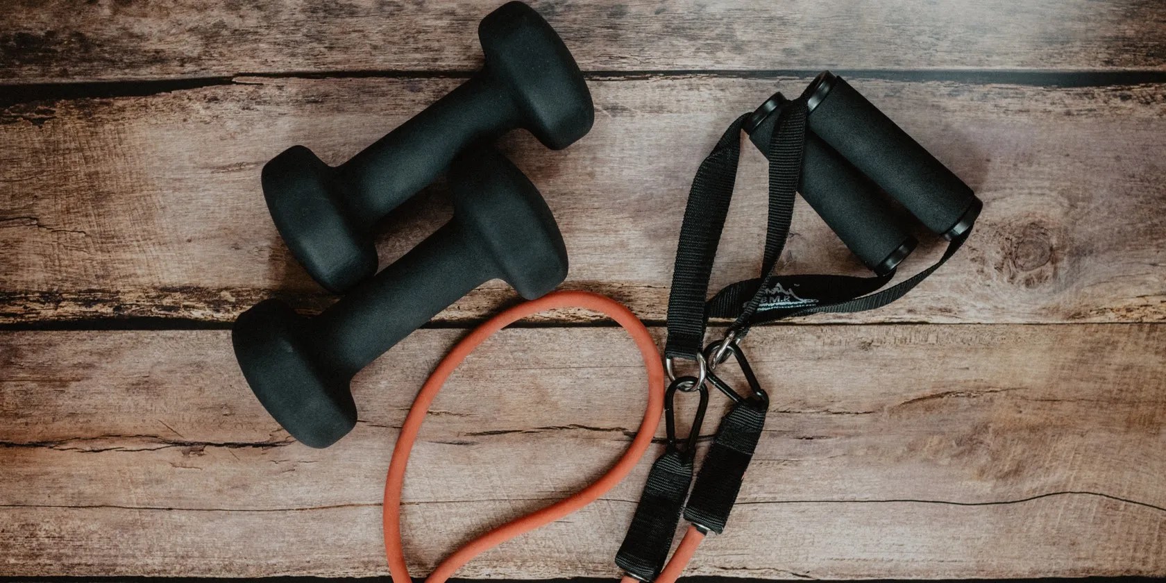 black exercise equipment dumbbells and cable on wooden floor