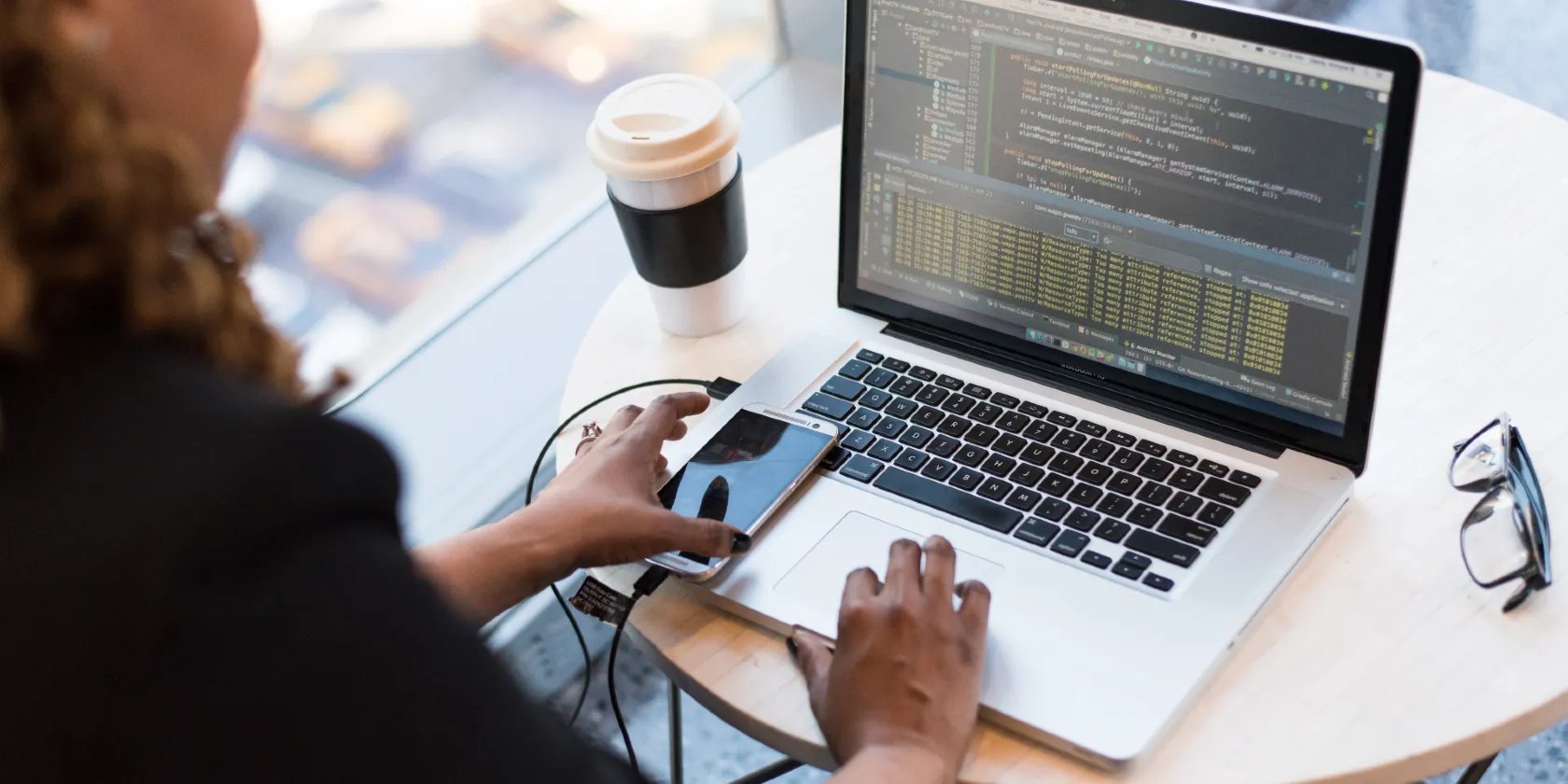 Black and Silver Laptop Computer on Round Brown Wooden Table