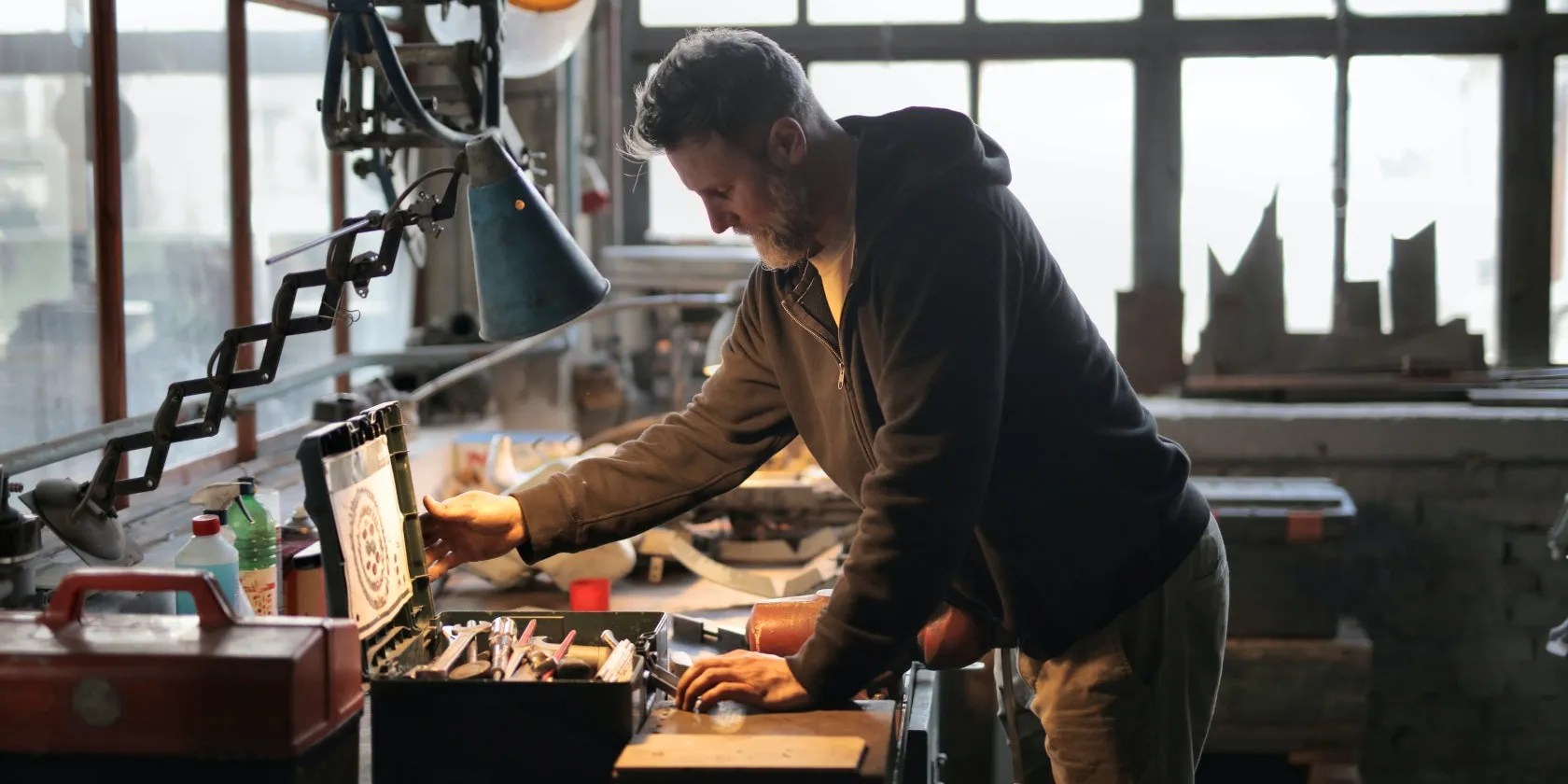 Man opening toolbox on a table