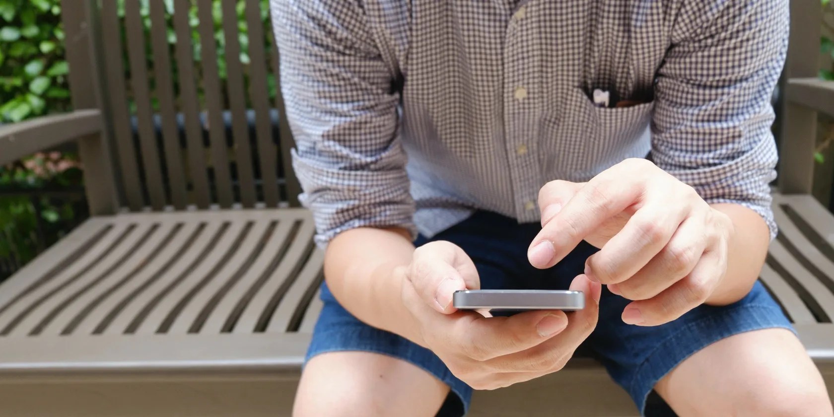 Man using phone on bench