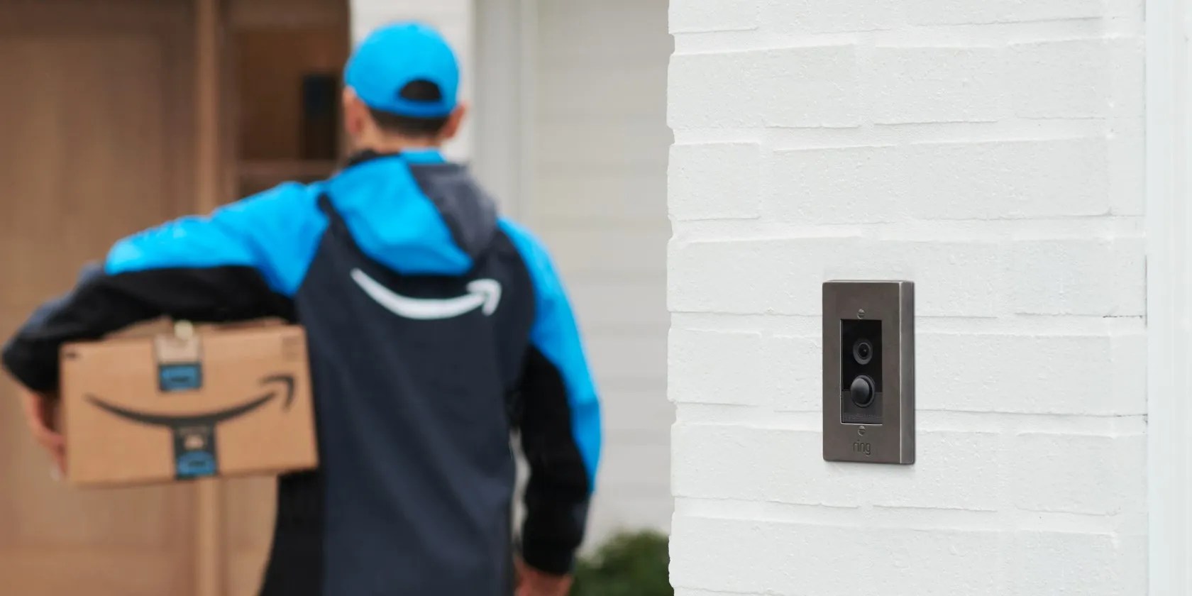 An Amazon employee delivering a package near a Ring camera