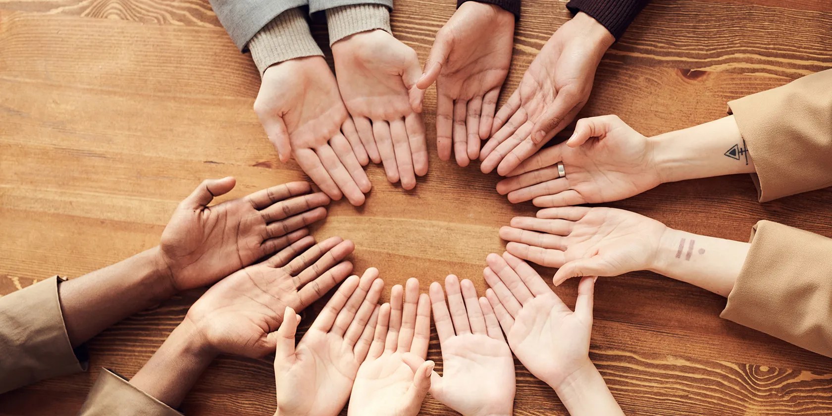 Hands in a circle on a table top
