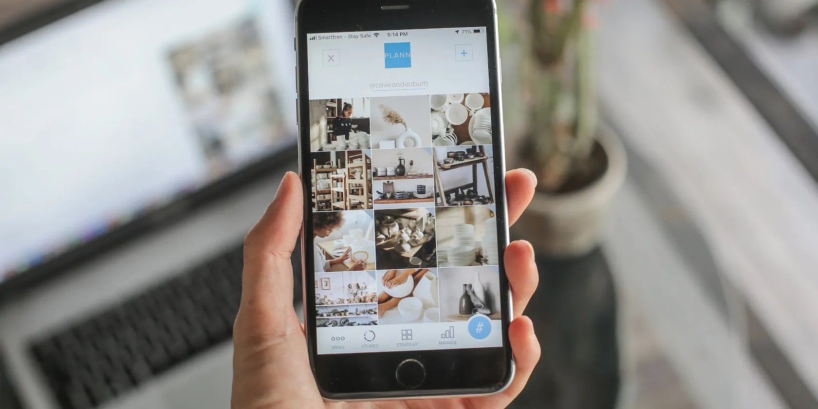 A hand holding an iPhone with a tab navigation on the screen