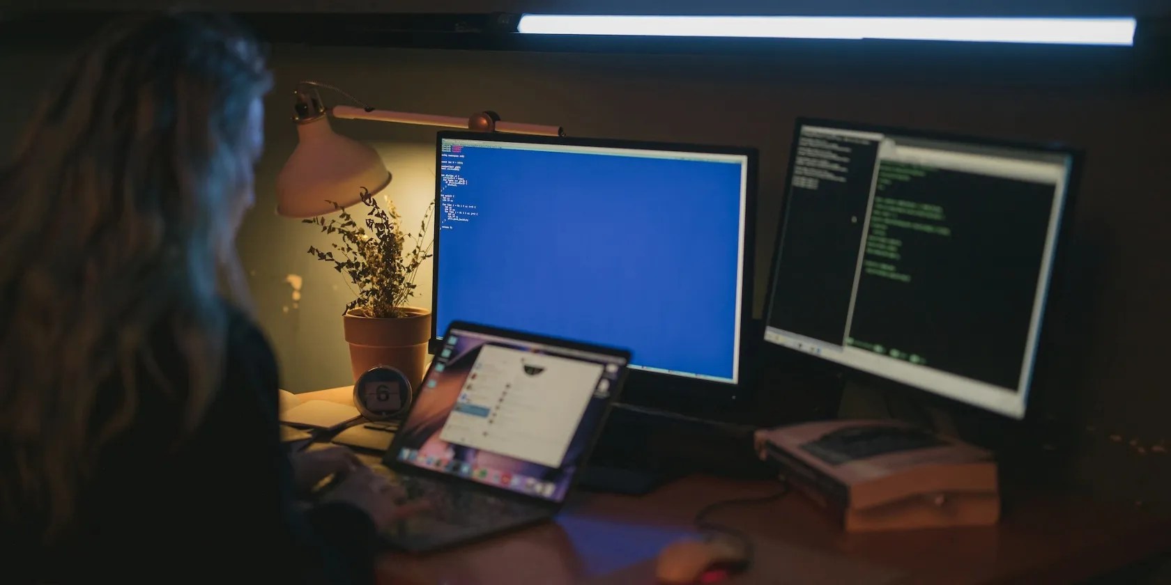 Person using three computers on a desk