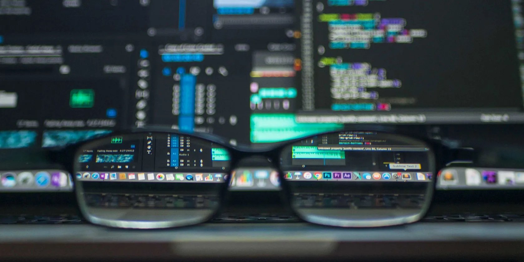 Glasses in front of blurred developer computer screen