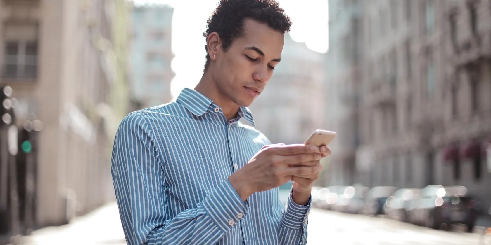 Man texting on a smartphone outside