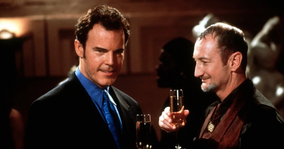 The djinn, disguised as Nathaniel Demerest, charms Raymond Beaumont