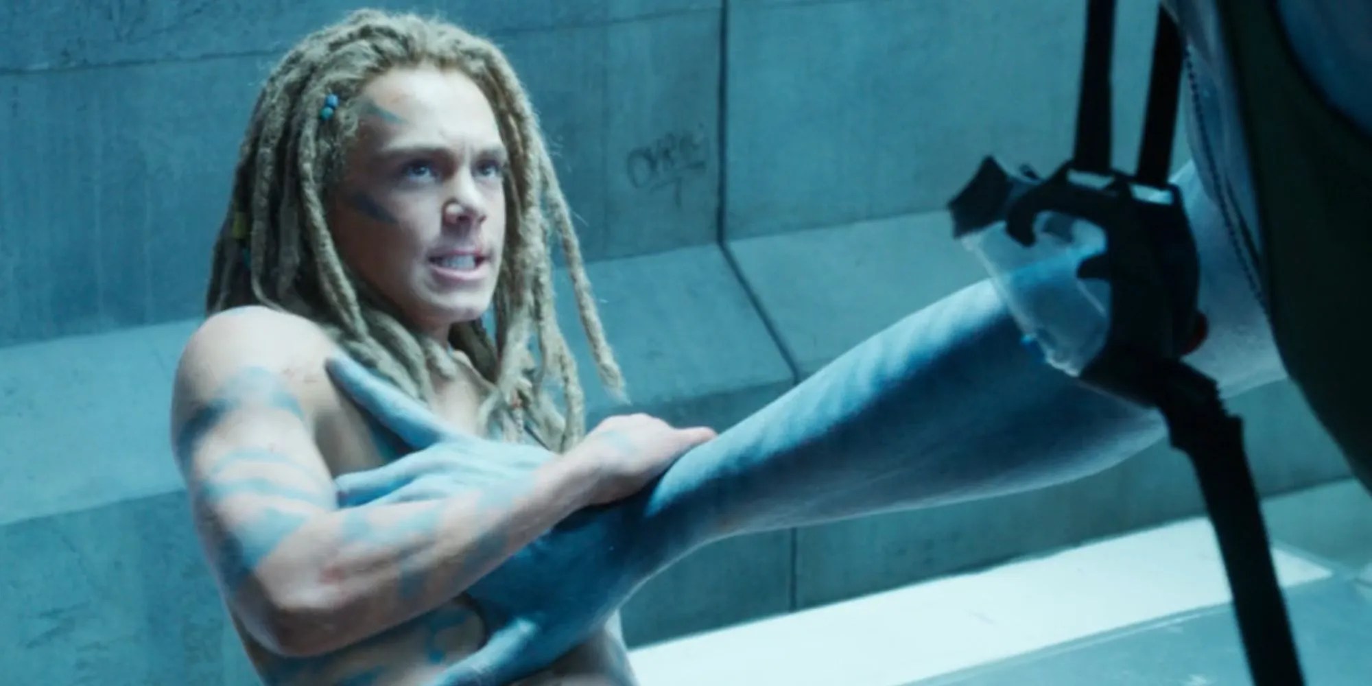 Jack Champion looking angry as Spider in Avatar: The Way of Water with Quaritch&rsquo;s arm pressing on his chest