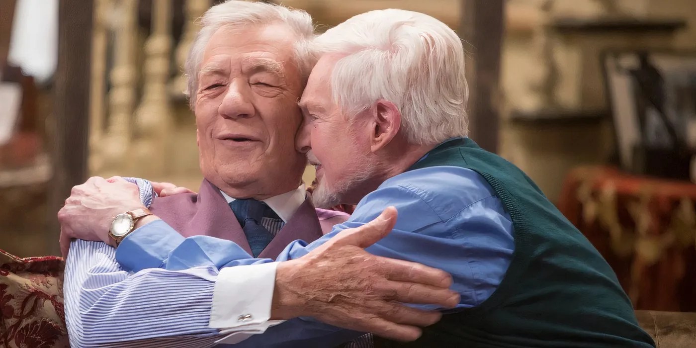 Ian McKellen as Freddie and Derek Jacobi as Stuart embracing happily as they sit on the couch in their living room in Vicious.