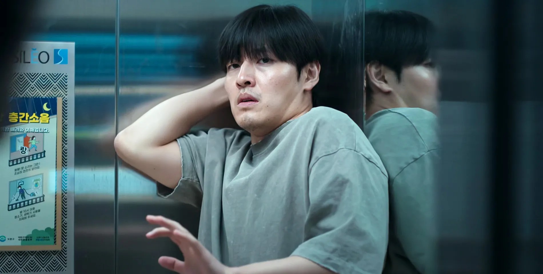 Kang Ha-neul is raising his hand up in the elevator in Wall to Wall