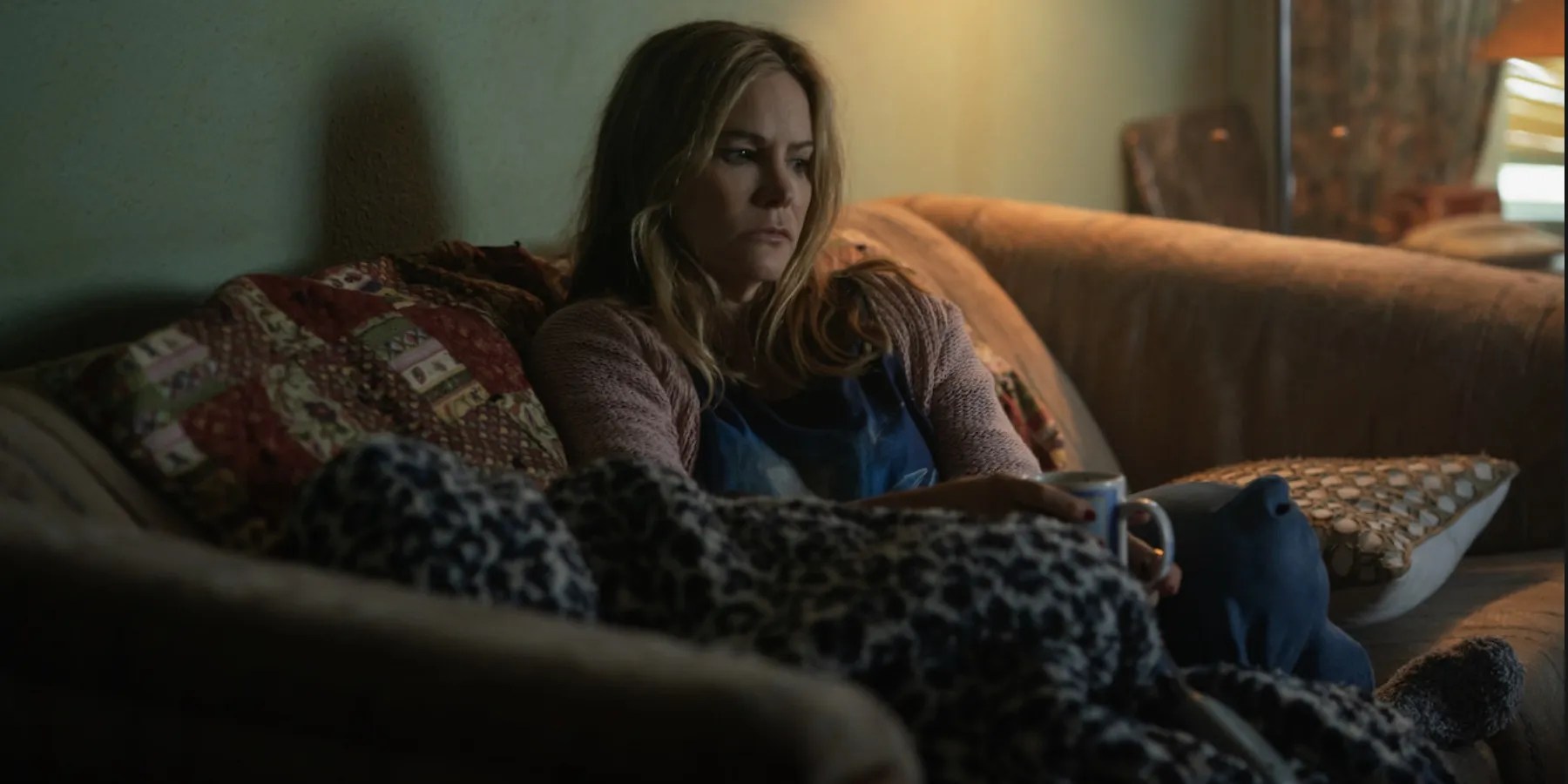 Jennifer Jason Leigh on a couch in Night Always Comes