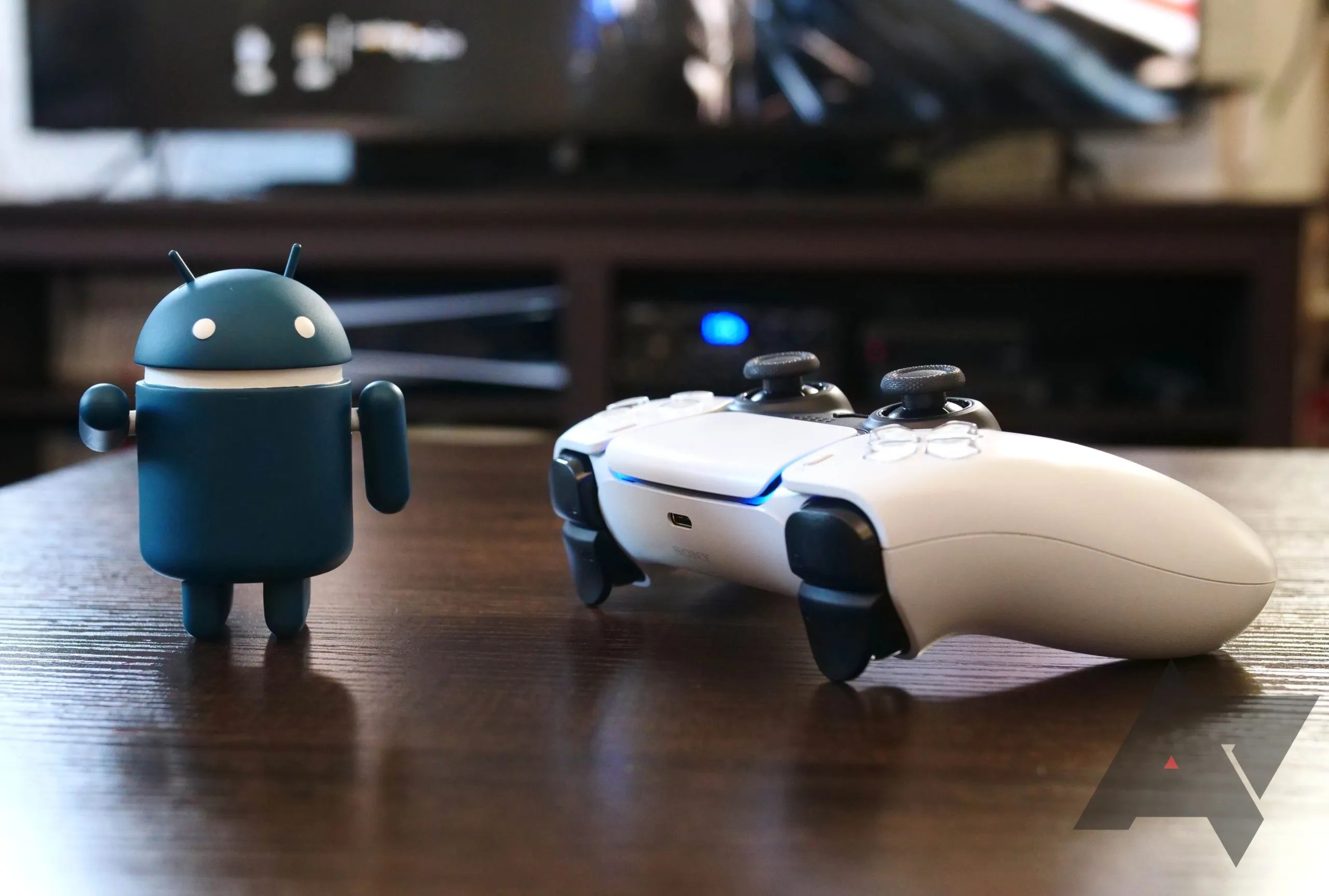 The PS5 sitting on a tabletop next to an Android figurine