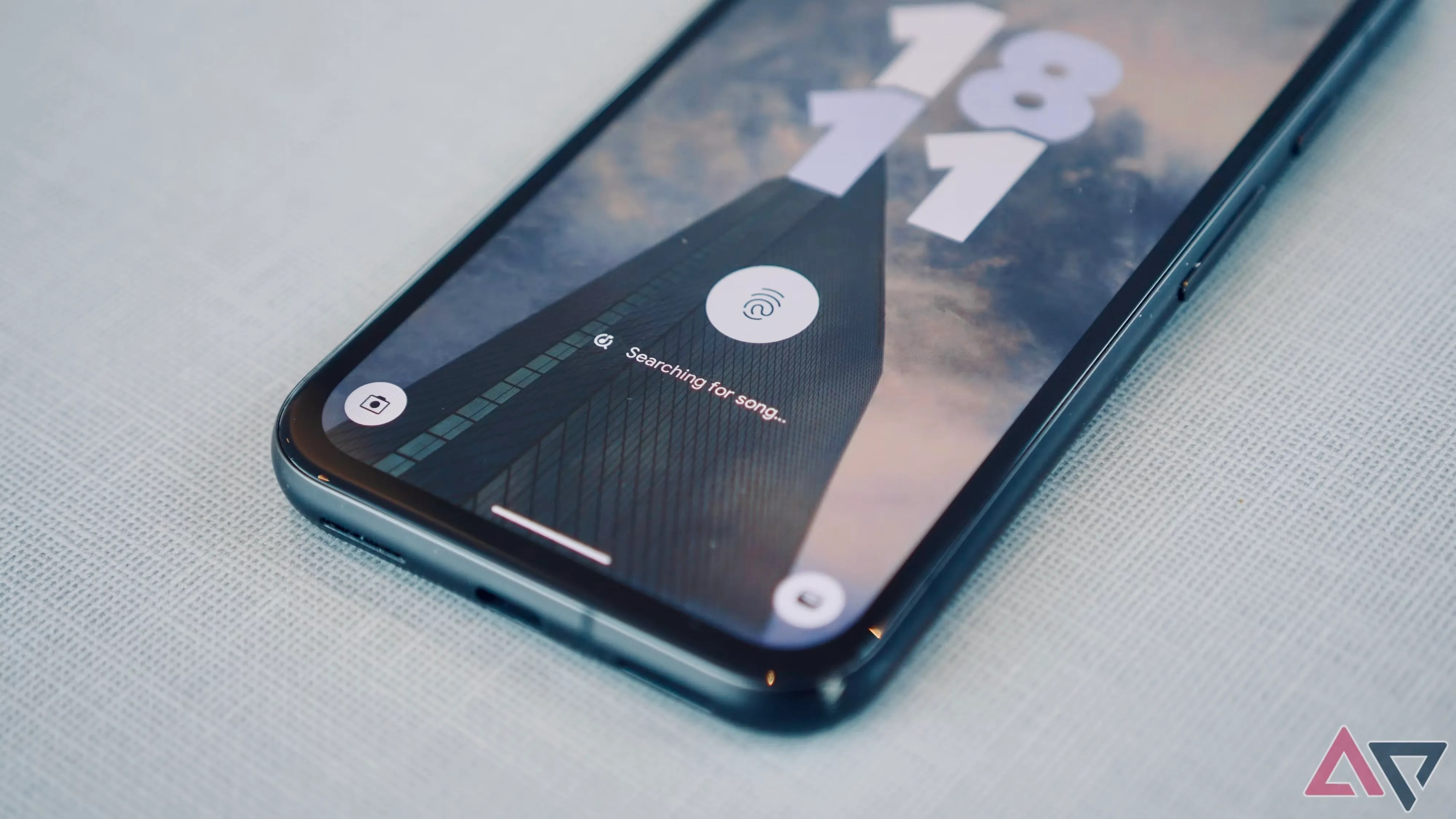 A Google Pixel 8a with its display illuminated against a gray background