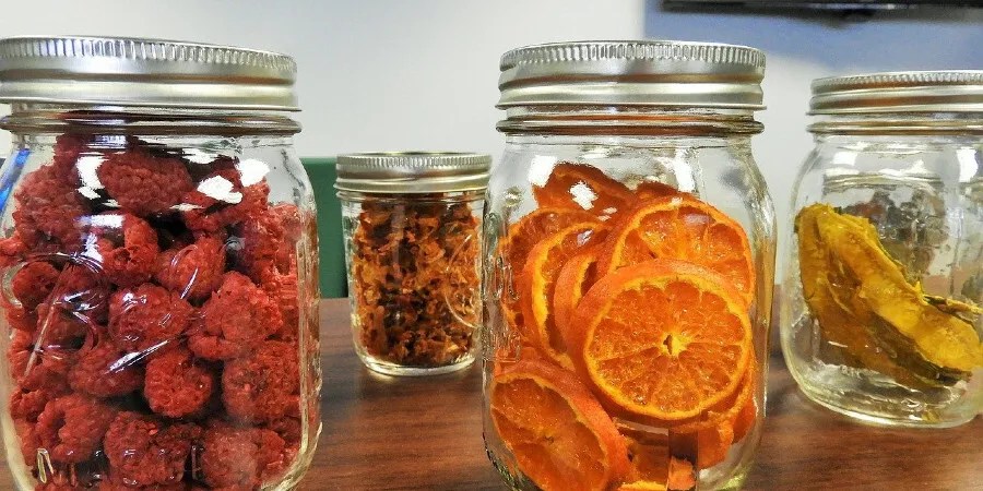 Glassed filled with dried fruit, including oranges and raspberries.