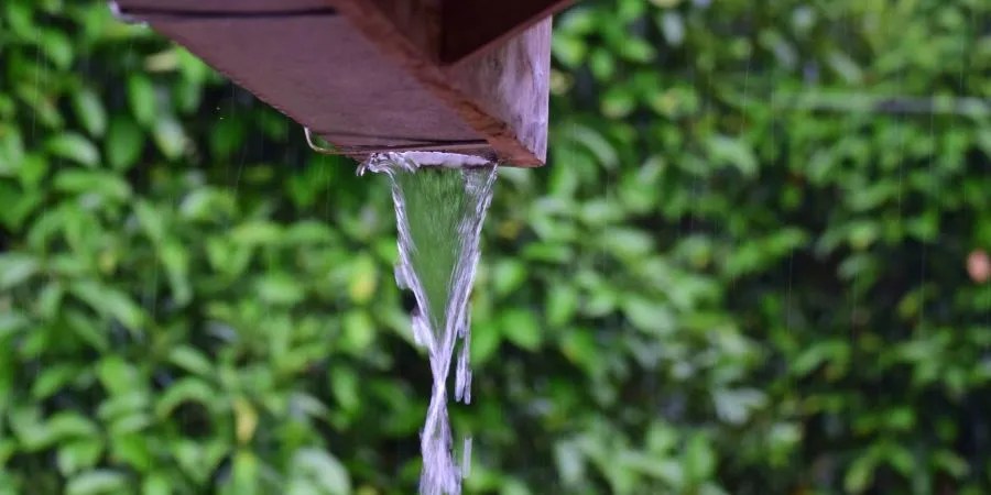 water flowing down the end of a rain gutter