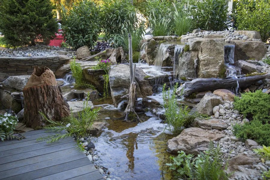 large water feature with multiple waterfalls and plants