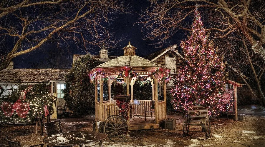 gazebo, fence, and other wooden structures lit up with Christmas lights