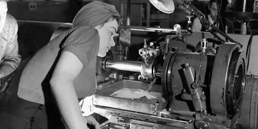 Black and white photo of person inspecting machinery