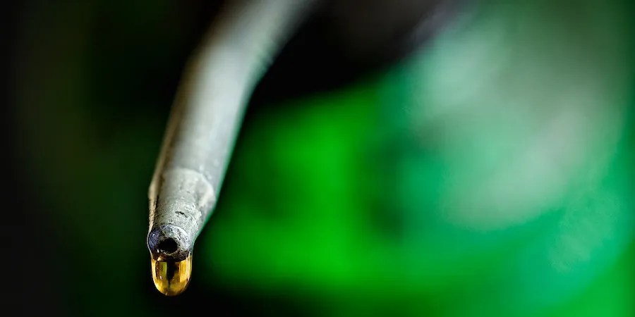 Lubricant dripping out of nozzle attached to green can