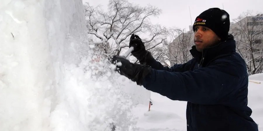 Man using a shovel to sculpt snow