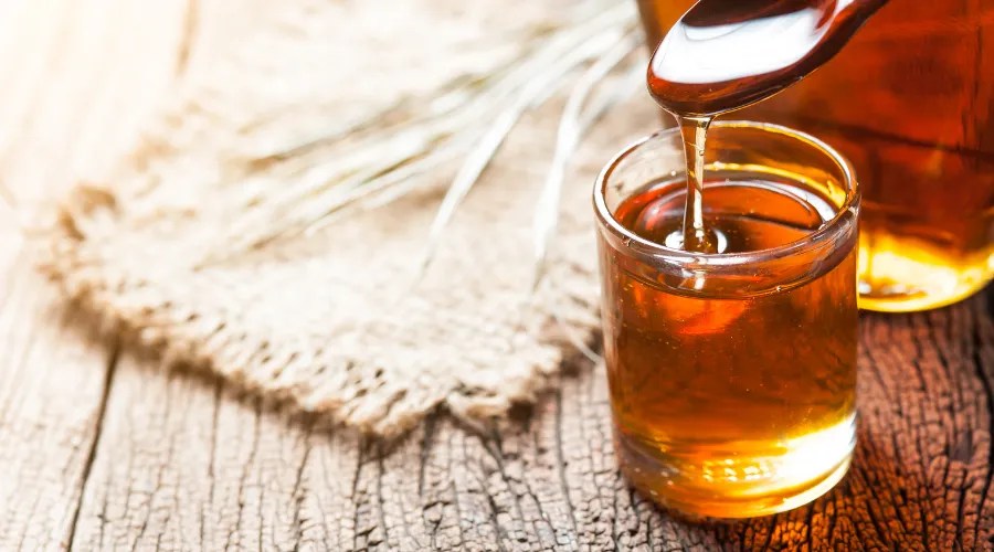 maple syrup in glass bottle on wooden table
