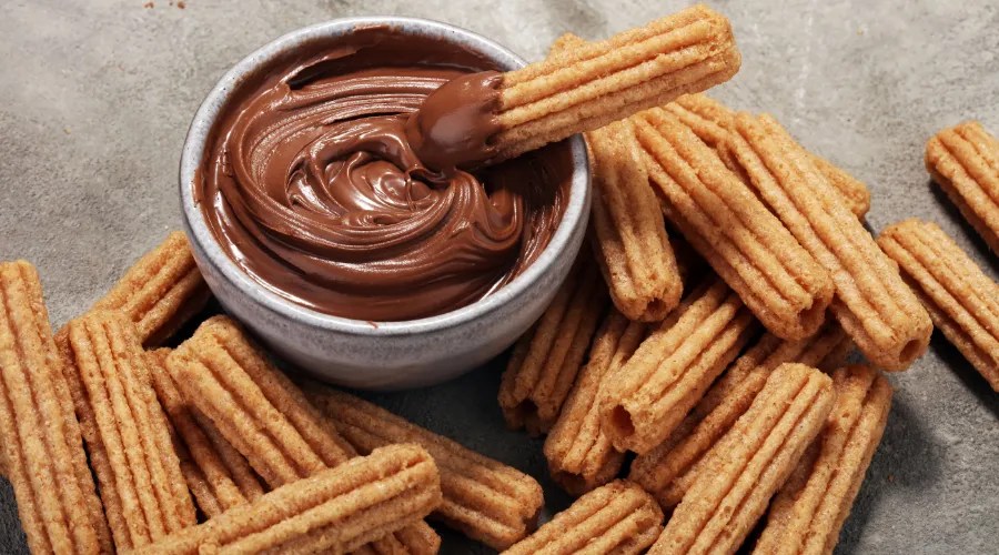 Traditional Spanish dessert churros with sugar and chocolate