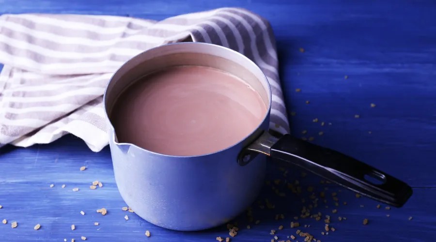 Metal Pot of Cocoa with Sugar and Napkin on Table