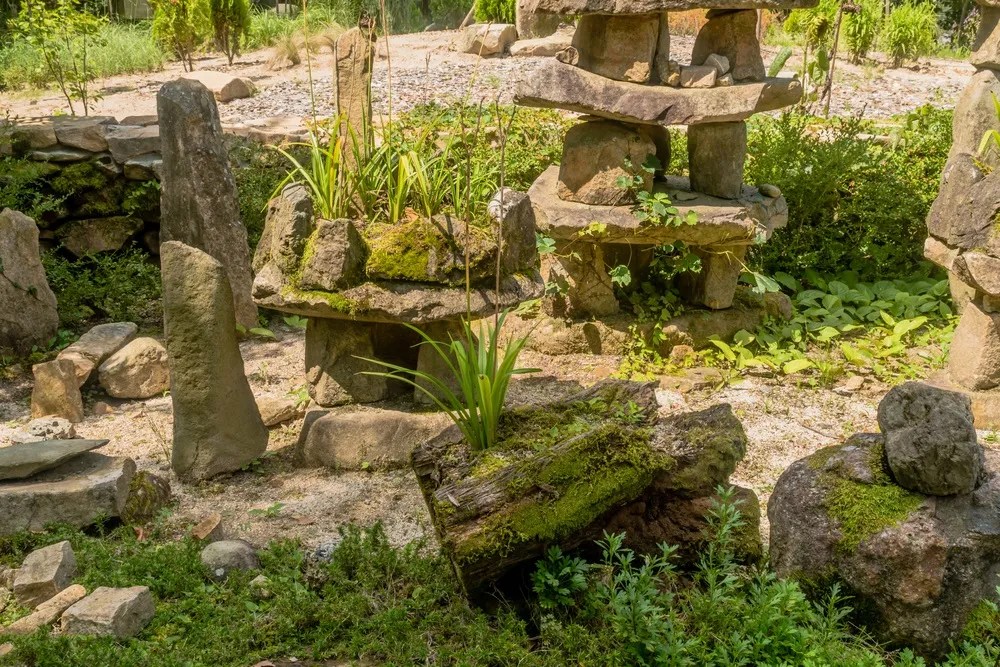 Beautiful stone garden at recreational forest park with bushes and trees in background.