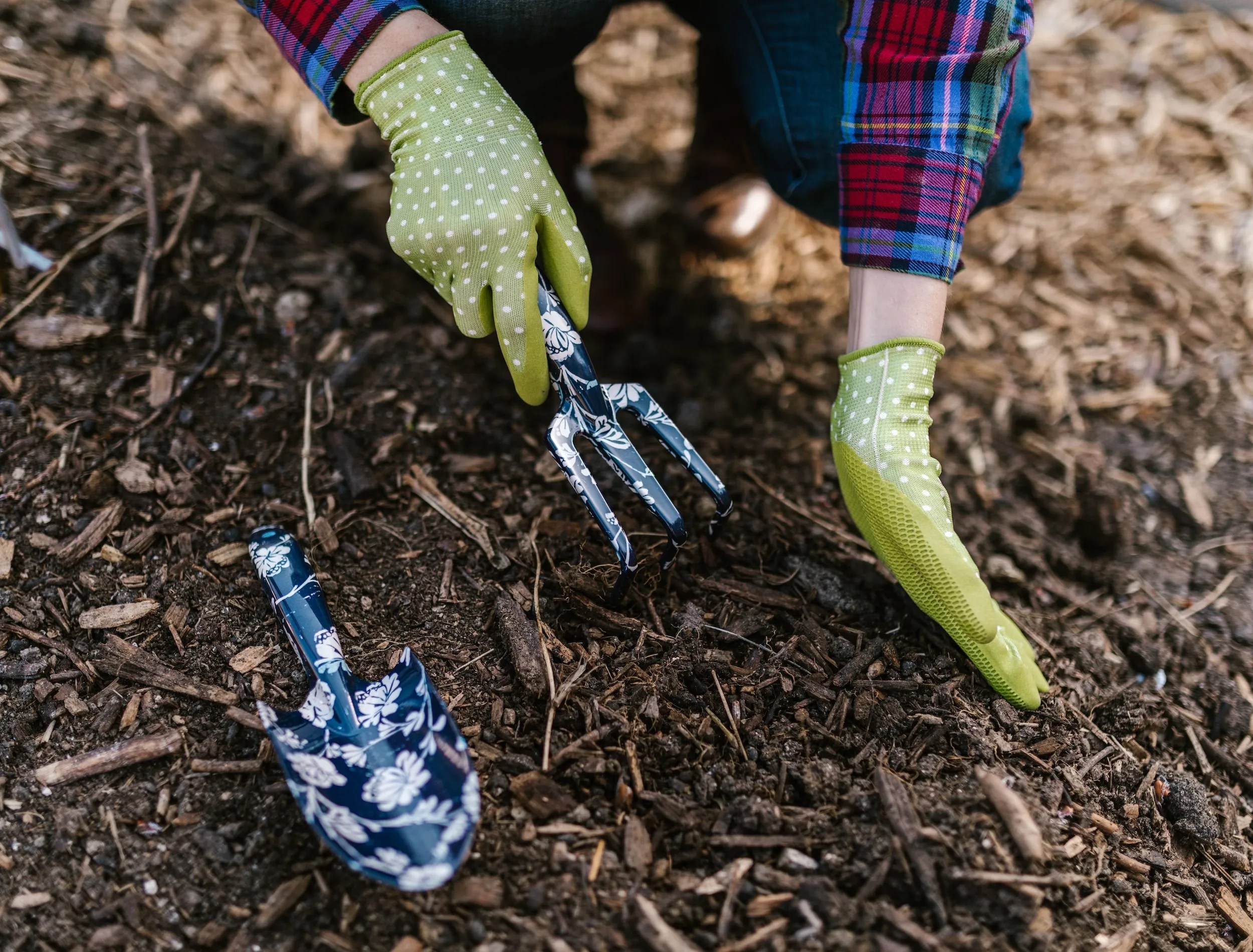 Person Wearing Green Gloves Holding Garden Tools