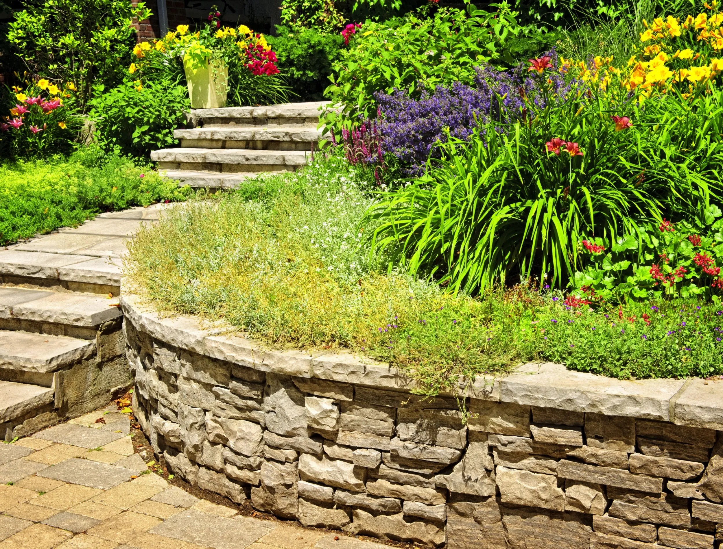 Kamień naturalny krajobrazu w ogrodzie domowym ze schodami i ścianami oporowymi