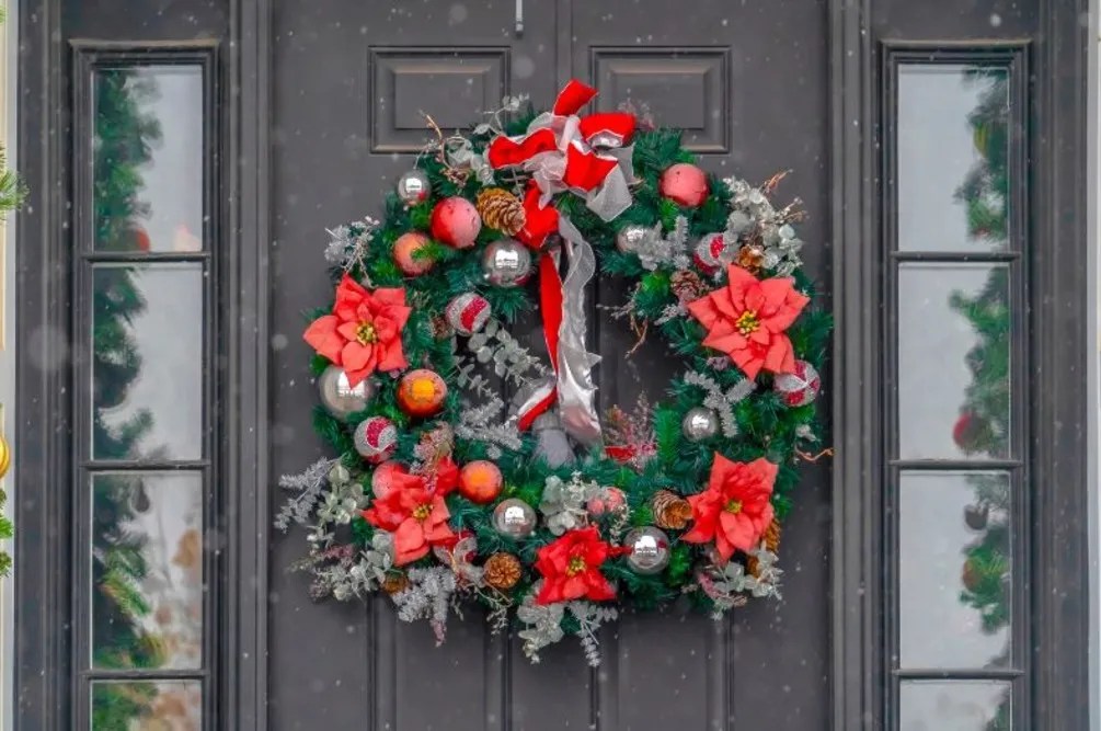 Front door adorned with a poinsettia wreath