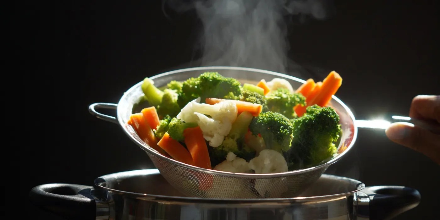 Blanching vegetables against black background
