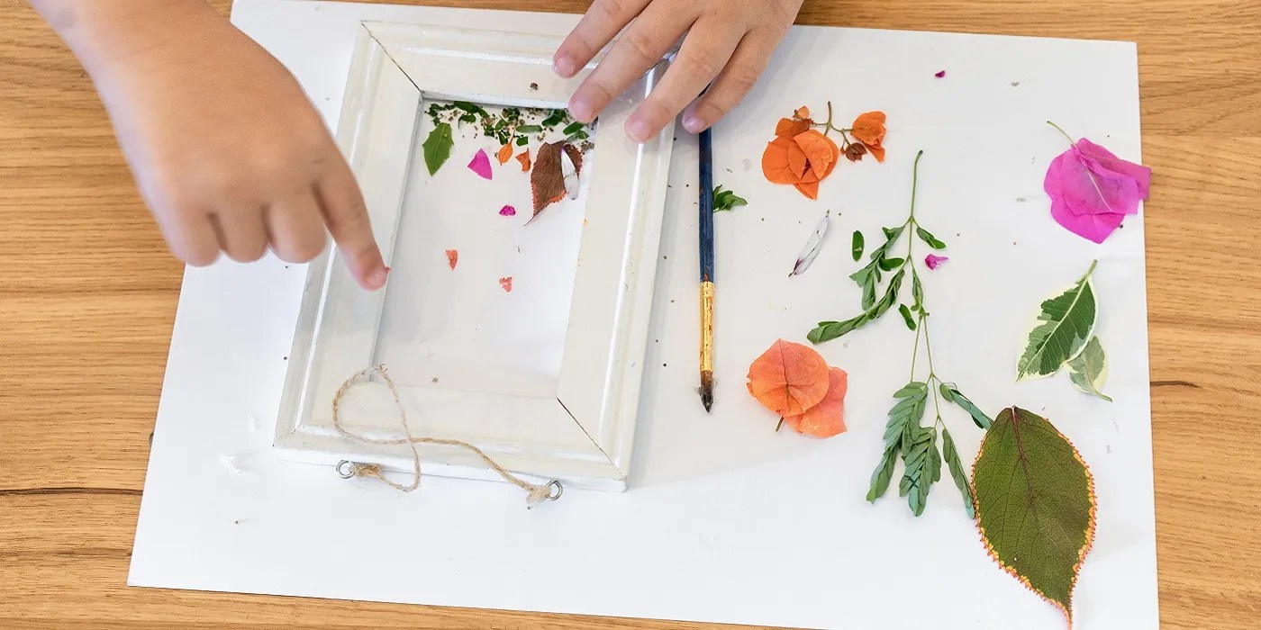 Creating pressed flower art on a wooden table