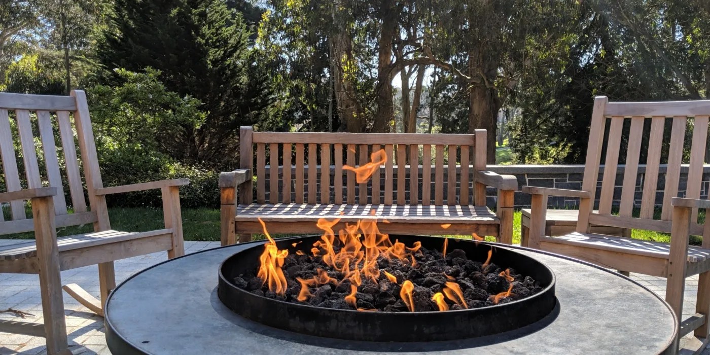 Several slat benches arranged around a firepit