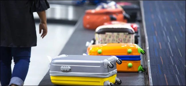 Wheeled suitcase on a luggage belt at the airport terminal