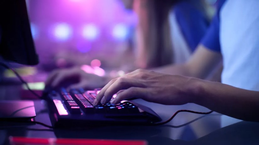 Gamer&rsquo;s hands on a PC keyboard