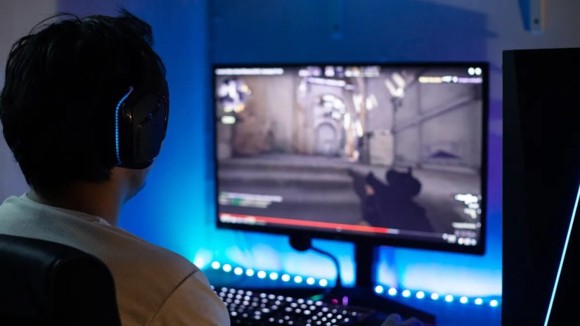 Back view of person playing a FPS game on PC