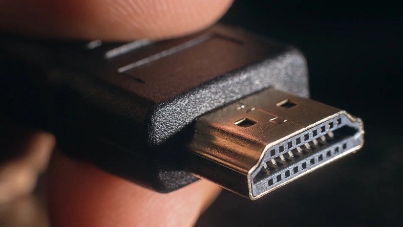 A hand holding an HDMI cable.