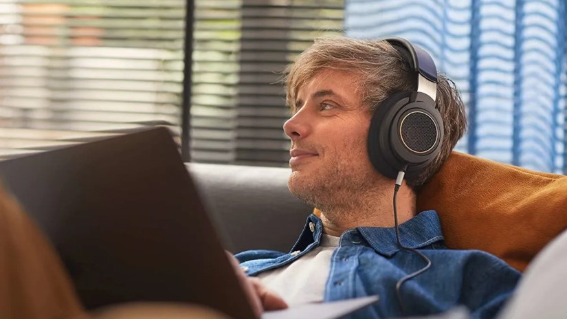 A man using Philips SHP9600 in a living area.