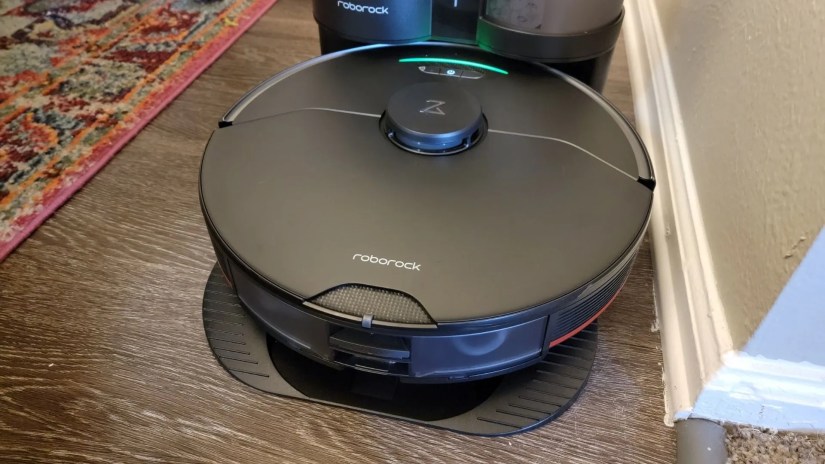roborock vacuum cleaner in its dock station on a wooden floor