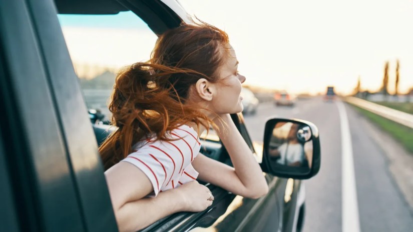 Woman leaning out car window.