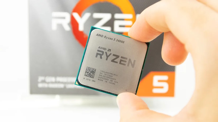 Closeup of an AMD Ryzen 5 3400G CPU held between a person&rsquo;s fingers.