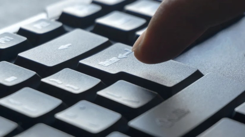 Finger pressing the enter key on a keyboard