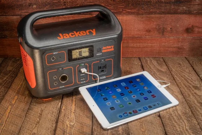 Jackery Explorer 500 Portable Power Station charging an iPad.