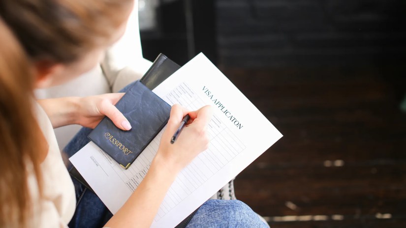 Woman filling out a paper visa application.