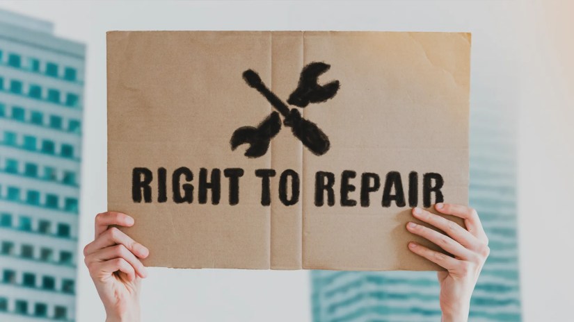 A person holding up a &ldquo;Right to Repair&rdquo; sign.