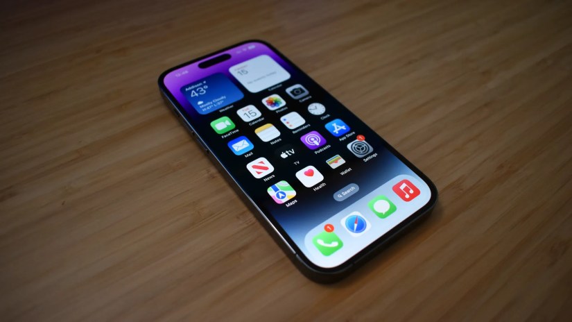 iPhone 14 Pro resting on desk with display on